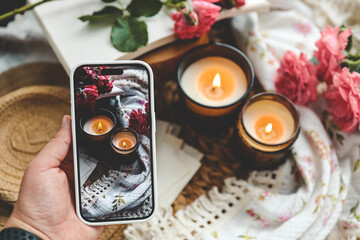 Obraz na płótnie Canvas Girl makes a photo, two burning candles in a spring interior