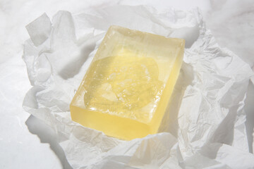 Natural bar soap for healthy skin and hair. Hydrating cleansing bar on crumpled package paper	