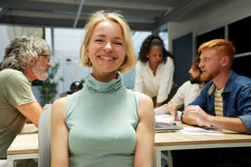 Portrait of an office cheerful Nordic mature woman and looking at camera. Empowered female leader....