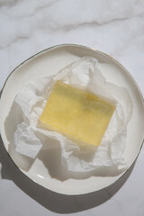 Natural bar soap for healthy skin and hair. Hydrating cleansing bar on crumpled package paper