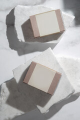 Natural bar soap for healthy skin and hair in recycled paper package with blank label, sudio shot on marbel background. Branding and advertaisment  of cosmetic products.