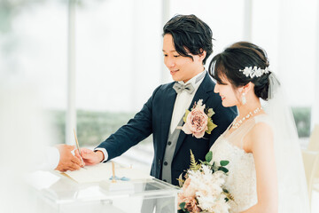 結婚式で結婚証明書・結婚誓約書にサイン・署名をする新郎新婦
