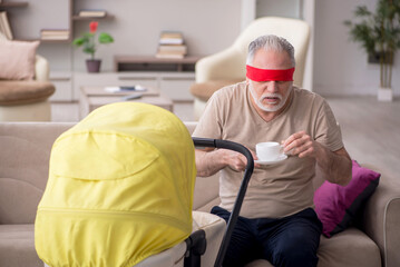 Old man looking after newborn at home