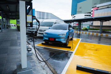 Fototapeta premium Electric car on electric car charging station. Power supply for electric car charging. Clean energy concept