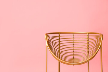 Golden armchair on pink background