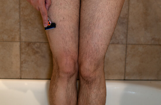 woman shaving her hairy legs in the shower 