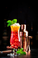 Aruba Ariba alcoholic cocktail drink with vodka, white rum, orange, lemon and pineapple juice, grenadine, dark bar counter background, copy space