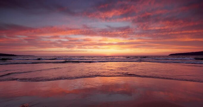 Ocean beach sunrise with color sky clouds and sun rays over sea waves 4K video