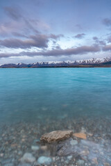 Scenic sunrise view of Lake Pukaki, with their mesmerizing turquoise hue and reflect the majestic snow-capped Southern Alps. Perfect for travel brochures, nature magazines, and inspirational content.