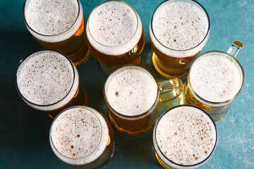 Glasses and mugs of cold beer on green background. Oktoberfest celebration