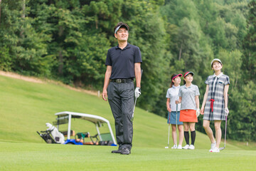ゴルフ場でゴルフをするゴルファーの男女
