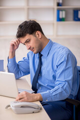 Fototapeta premium Young male employee working in the office
