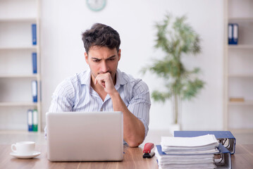 Naklejka premium Young male employee working in the office