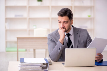 Naklejka premium Young male employee working in the office