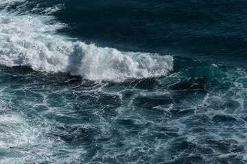 Fototapeta na wymiar The waves of the ocean water meet with underwater pointed rocks
