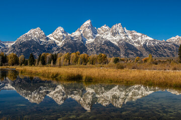 reflection of the teton mountains in the fall