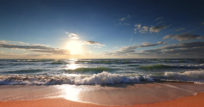 Ocean beach sunrise with color sky clouds and sun rays over sea waves 4K video