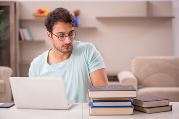 Young male student preparing for exams at home