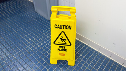 Bright yellow caution sign with 'wet floor' text symbolizes potential hazards, urging caution and prevention in slippery conditions