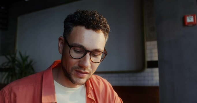 A stylish young man eats bruschetta in a cafe. Close-up of a man's face