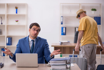 Old male boss and young male employee in summer vacation concept