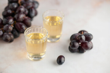Traditional Georgian  chacha, also known as grape vodka or Georgian grappa in shot glasses  and fresh grapes