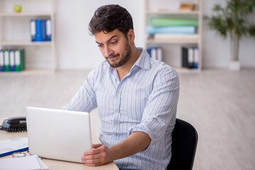 Young male employee working in the office