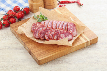 Sliced salami sausages over board