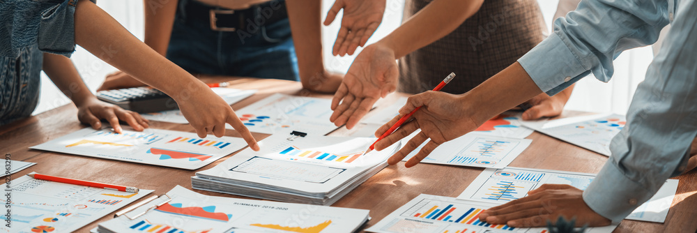 Leinwandbilder Analyst team utilizing BI Fintech to analyze and pointing at financial dashboard paper office. Businesspeople examining report paper on table for business insight. Panorama shot. Scrutinize