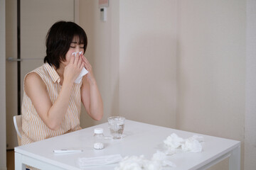 風邪をひいて鼻をかむ若い女性