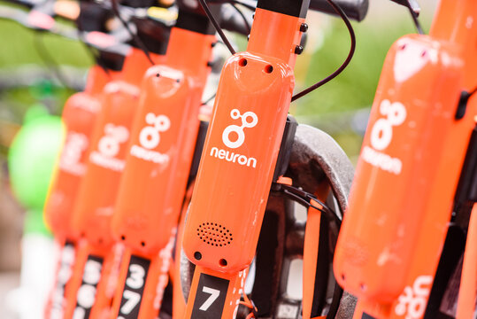 A row of orange Neuron e-scooters are available for hire in the city centre of Melbourne