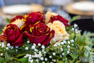 bouquet of red and white roses with gold glitter.