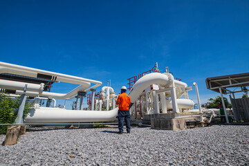 Male worker inspection at steel long pipes and pipe elbow in station oil factory during refinery...