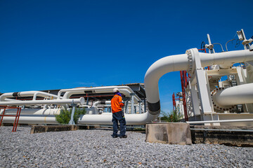 Male worker inspection at steel long pipes and pipe elbow in station oil factory during refinery valve of visual check record pipeline oil