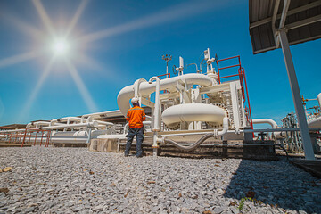 Male worker inspection at steel long pipes and pipe elbow in station oil factory during refinery...