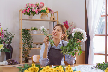 Floristry concept, Woman florist choosing white chrysanthemum to making bouquet in flower shop