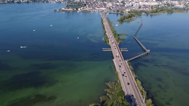 Rapperswil, Switzerland: Aerial drone footage of the bridge over Lake Zurich toward the rapperswil-Jona city in canton Saint Gallen on the sunny summer day with a tilt up motion. 