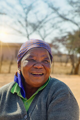 village life, old african woman in the yard laughing from the heart