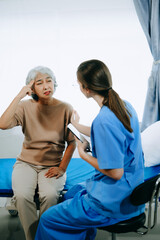 Obraz premium Friendly Female Head Nurse Making Rounds does Checkup on Patient Resting in Bed. She Checks tablet while Man Fully Recovering after Successful Surgery in hospital.