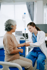 Friendly Female Head Nurse Making Rounds does Checkup on Patient Resting in Bed. She Checks tablet while Man Fully Recovering after Successful Surgery in hospital.