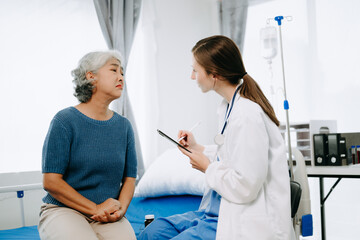 Obraz premium Friendly Female Head Nurse Making Rounds does Checkup on Patient Resting in Bed. She Checks tablet while Man Fully Recovering after Successful Surgery in hospital.