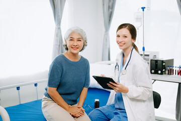  Caucasian doctor smiling take care of a young patient in hospital. Friendly nurse or therapeutic treat client Professional medical service concept.