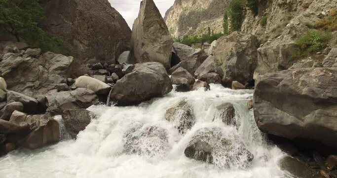 Drone footage of flowing river in the northern Pakistan gilgit baltistan Pakistan beautiful view of flowing river thorough mountains and rocks nature background 