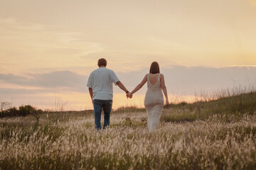 pareja enamorados caminando de la mano puesta de sol
