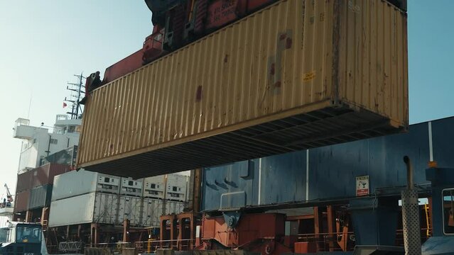 4K actual cam scene of crane lifting down container on cargo trailer at commercial port stock video. 
