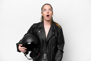 Fototapeta premium Young caucasian girl with a motorcycle helmet isolated on white background looking up and with surprised expression