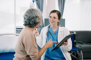 Fototapeta premium Female doctor in white medical coat discussing elderly patient in clinic, therapist. Consulting woman examining pain, health care, medicine concept.