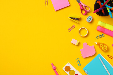 Back to school concept. Flat lay composition with school supplies on yellow background. Top view...