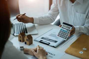 Obraz na płótnie Canvas home loan officer uses a calculator with a house plan.