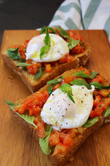 Delectable Pair of Toast with Poached Egg on Fresh Tomatoes and Basil Leaves